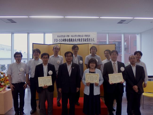 授賞式後の学科教員集合写真（前列中央：落合学部長，前列右端：清水学部次長）